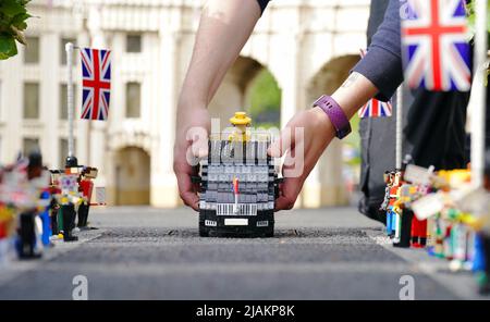 Model Maker Freya Groom colloca una replica della Regina Elisabetta II, riimmaginata in mattoni LEGO, in un veicolo animato come parte del Platinum Jubilee Display presentato oggi al LEGOLAND Windsor Resort. La regina animata e il veicolo ha preso 15hrs per costruire utilizzando 1.350 mattoni. LEGOLAND Windsor Resort ha presentato oggi i suoi modelli di ispirazione regale per celebrare il Giubileo del platino della Regina. Il numero complessivo di mattoni utilizzati è stato di 18.001 e i modelli hanno impiegato un totale di 281,5 ore per finire. Il display include anche una festa di strada e scena pic-nic, così come le versioni in miniatura dei reali, l'albero di Foto Stock