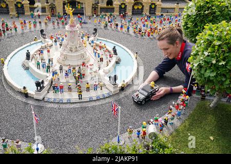 Model Maker Freya Groom colloca una replica della Regina Elisabetta II, riimmaginata in mattoni LEGO, in un veicolo animato come parte del Platinum Jubilee Display presentato oggi al LEGOLAND Windsor Resort. La regina animata e il veicolo ha preso 15hrs per costruire utilizzando 1.350 mattoni. LEGOLAND Windsor Resort ha presentato oggi i suoi modelli di ispirazione regale per celebrare il Giubileo del platino della Regina. Il numero complessivo di mattoni utilizzati è stato di 18.001 e i modelli hanno impiegato un totale di 281,5 ore per finire. Il display include anche una festa di strada e scena pic-nic, così come le versioni in miniatura dei reali, l'albero di Foto Stock