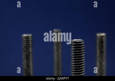 piccoli oggetti industriali in primo piano su sfondo blu Foto Stock