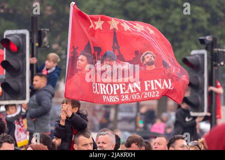 Giovane fan con la grande bandiera Liverpool Football Club vittoria sfilata attraverso le strade della città per celebrare la Coppa di Lega e fa Cup trofei vittorie Foto Stock