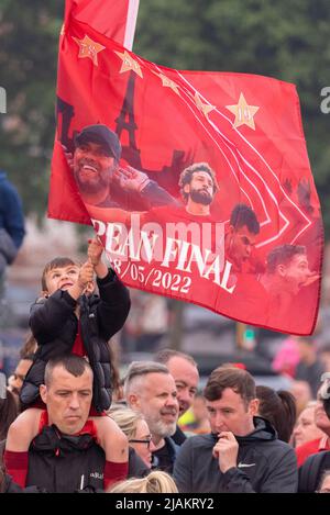 Giovane fan con la grande bandiera Liverpool Football Club vittoria sfilata attraverso le strade della città per celebrare la Coppa di Lega e fa Cup trofei vittorie Foto Stock