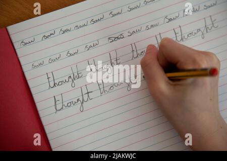 Primo piano di una mano di bambini che pratica la scrittura a mano a scuola Foto Stock