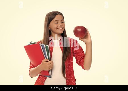 felice bambino tenere copybook scuola per lo studio e pranzo mela isolato su bianco, di nuovo a scuola Foto Stock