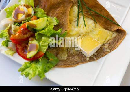 Frittella fritta con formaggio fuso e insalata, piatto di cucina francese Foto Stock