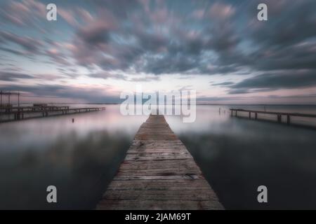 Moli di legno e barche per l'allevamento di ostriche a Etang de Thau, nel sud della Francia Foto Stock