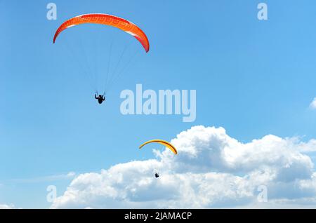 Parapendio in volo contro il cielo. Foto Stock