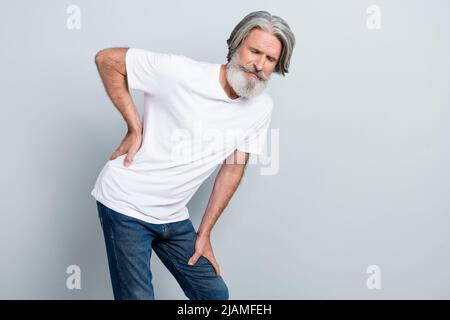 Ritratto di attraente uomo grigio-capelli tristi toccare indietro sofferente isolato su sfondo grigio color pastello. Foto Stock