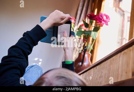 28 maggio 2022, Berlino: Un ragazzo si trova su una panchina e cerca qualcosa su Internet sul suo cellulare. Foto: Annette Riedl/dpa Foto Stock