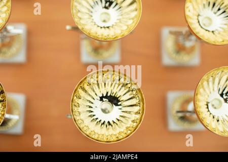 Coppa del vincitore. Le tazze d'oro si alzano in fila. Premio ai campioni. Foto Stock