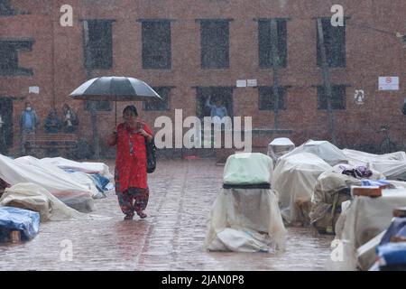 Il May31, 2022 a Kathmandu, Nepal. Le donne che trasportano l'ombrello camminano attraverso i negozi di curios di strada che sono coperti di plastica durante il giorno piovoso. (Foto di Abhishek Maharjan/Sipa USA) Foto Stock