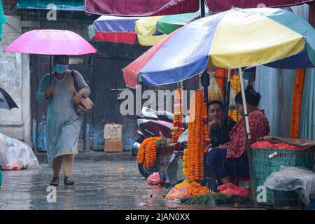 Il May31, 2022 a Kathmandu, Nepal. Le donne che trasportano l'ombrello passano attraverso i negozi di fiori di strada mentre i venditori di fiori aspettano i loro clienti in mezzo al giorno piovoso. (Foto di Abhishek Maharjan/Sipa USA) Foto Stock