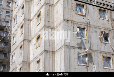 Semplice generico immobile nuovo a sinistra incompiuto, dettaglio, blocco di appartamenti, muri in calcestruzzo grezzo, finestre. Cantiere, edilizia abitativa i Foto Stock