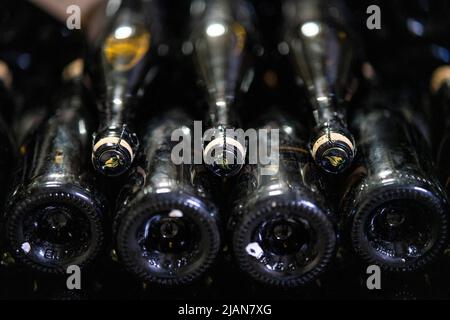 Bottiglie di champagne impilate in una cantina Foto Stock