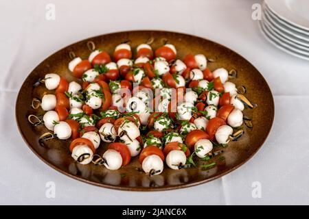 mozzarella con pomodori, spiedini su un piatto Foto Stock