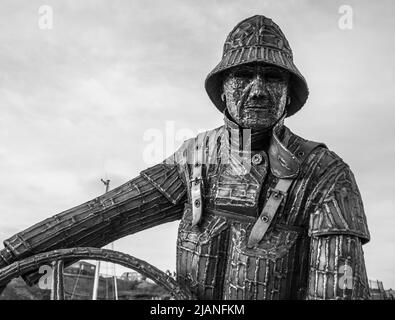 La statua coxswain scolpita dall'artista South Hetton, Ray Lonsdale, e situata presso il porto turistico di Seaham, nel nord-est dell'Inghilterra, UK.in monocromatico Foto Stock