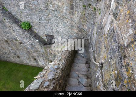 Il castello di Harlech è un edificio di prima categoria e un sito patrimonio dell'umanità dell'UNESCO sulla costa del Galles del Nord. Scalini stretti giù dai merlamenti. Foto Stock