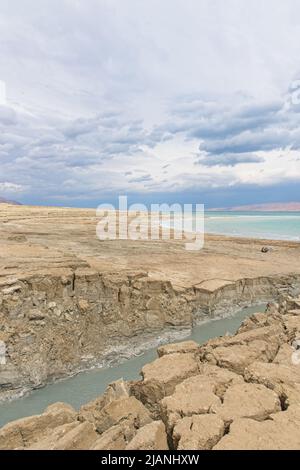 Buca piena di acque turchesi, vicino alla costa del Mar Morto. Foro formato quando il sale sotterraneo è dissolto da intrusione di acqua dolce, dovuto la caduta continua del livello del mare. . Foto di alta qualità Foto Stock