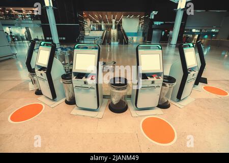 Un gruppo di sei terminali elettronici per il check-in self-service, il deposito bagagli e la stampa di carte d'imbarco basati su un semicerchio, con mockup dei loro LCD Foto Stock