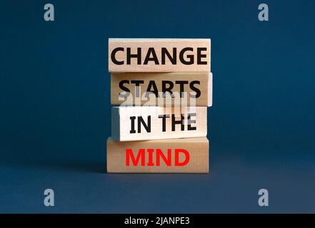 Il cambiamento inizia nel simbolo della mente. Concetto parole il cambiamento inizia nella mente su blocchi di legno su un bel sfondo grigio tabella. Business, motiva Foto Stock