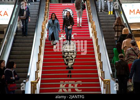 Mosca, Russia. 29th maggio 2022. Pubblicità della catena di fast food KFC su una scala nel centro commerciale Okhotny Ryad nel centro di Mosca, Russia Foto Stock