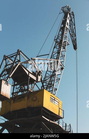 La gru portuale industriale è sotto il cielo blu Foto Stock