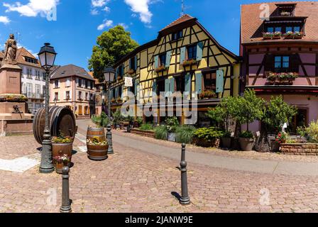 Ribeauville, Francia - 30 maggio, 2022: Il centro storico del villaggio di Ribeauville con fontana e botti di vino nella piazza del paese Foto Stock