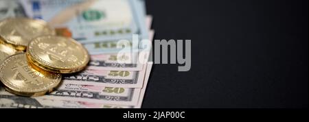 Closeup bitcoins su bollette di cinquanta dollari. Acquisto con valuta digitale o denaro cartaceo. Denaro e cripto in dollari USA. Spazio di copia sul lato destro Foto Stock