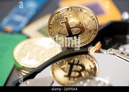 Riflessione Bitcoin sul disco rigido. Dispositivo di stoccaggio riflettente che riflette la moneta BTC. Concetto di criptovaluta e stoccaggio blockchain Foto Stock