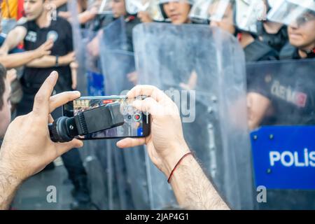 Gezi Park protesta il 31 maggio 2022. Uomo che registra poliziotti in fila con uno smartphone. Beyoglu, Taksim, İstiklal Avenue Foto Stock