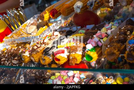 Gustosi churros in vendita in una stalla di strada Foto Stock