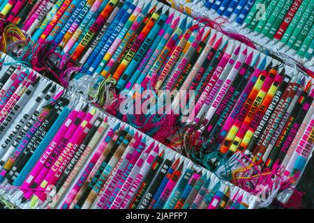 Lo stand con braccialetti multicolore con nomi diversi. Foto Stock