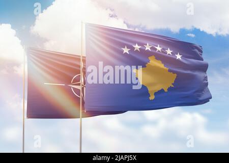 Cielo azzurro soleggiato e bandiere del kosovo e della nato Foto Stock