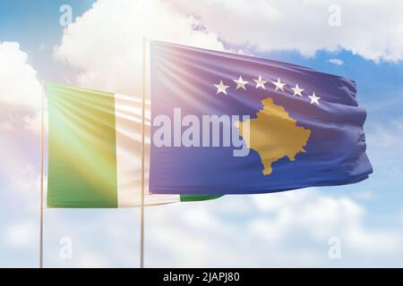 Cielo azzurro soleggiato e bandiere del kosovo e della nigeria Foto Stock