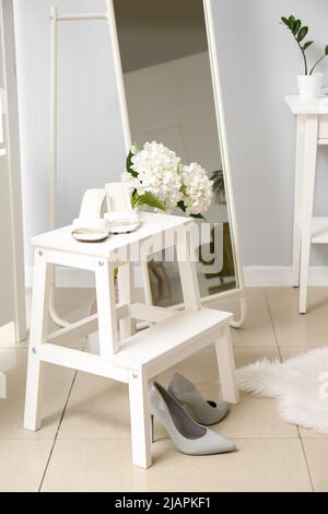 Scala a gradini con scarpe eleganti e bellissimi fiori in camera Foto Stock