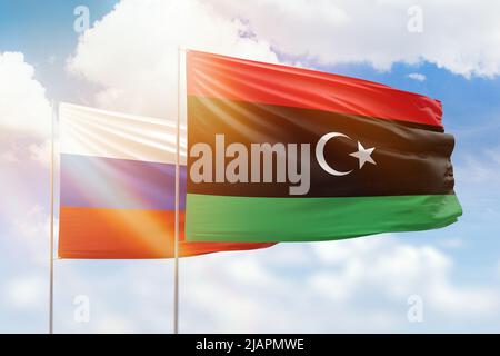 Cielo azzurro soleggiato e bandiere di libia e russia Foto Stock