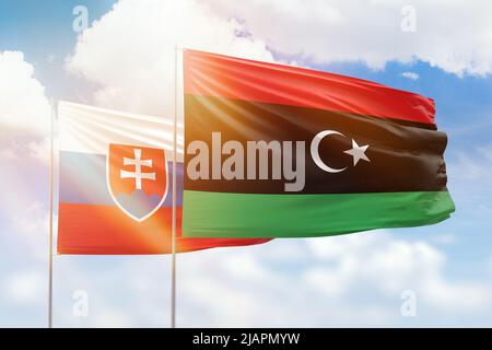 Cielo azzurro soleggiato e bandiere di libia e slovacchia Foto Stock