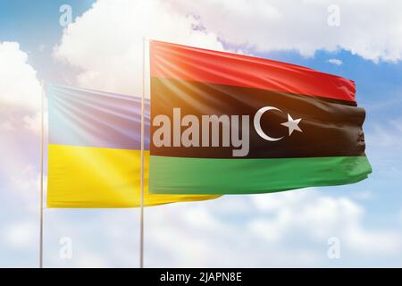 Cielo azzurro soleggiato e bandiere di libia e ucraina Foto Stock