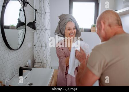 Coppia anziana in bagno, spazzolando i denti e lavando, concetto di routine del mattino. Foto Stock