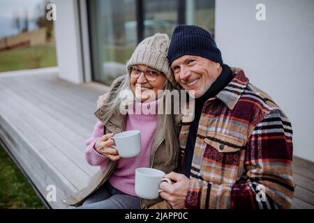 Coppia anziana felice seduta sulla terrazza e bere caffè insieme. Foto Stock