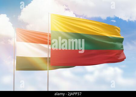 Cielo azzurro soleggiato e bandiere di lituania e ungheria Foto Stock