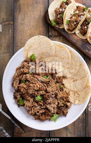 Carnitas tacos di maiale con cipolla e coriandolo servito con tortillas di mais Foto Stock