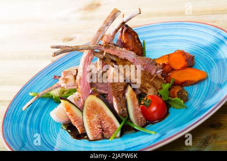 Costolette di montone arrosto con fichi, verdure, salsa demi-glace Foto Stock