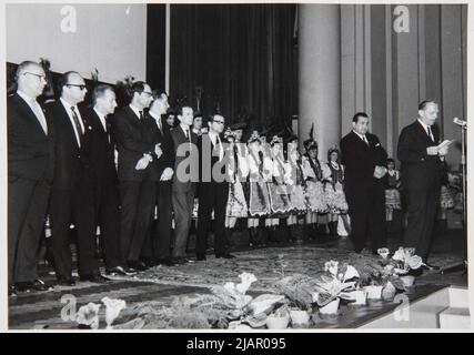 Skarżyński Jerzy in piedi sulla prospettiva del cinema di Kyiv a Cracovia tra i giurati del Festival Nazionale dei cortometraggi 5th (prima da destra) 1965 poi ballerini a Cracovia costumi folcloristici dietro il diffusore al microfono, il presidente della città di Cracovia Zbigniew Skolicki. Węglowski, Edoardo Foto Stock