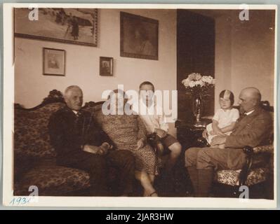 La famiglia Stachiewicz all'interno del soggiorno di Chorzelów si siedono sul divano, da sinistra: Feliks Borowski, Stefania Siemiątkowska (sorella Feliks) e suo figlio; sul lato destro Roman Stachiewicz siede sulla poltrona, difendo mia figlia in grembo; Quattro dipinti di Piotr Stachiewicz appendono sulla parete a sinistra. Cerchio della famiglia Stachiewicz Foto Stock