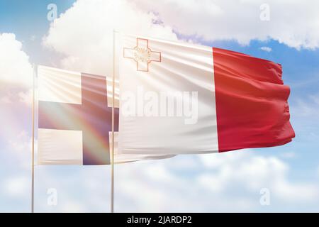 Cielo azzurro soleggiato e bandiere di malta e finlandia Foto Stock
