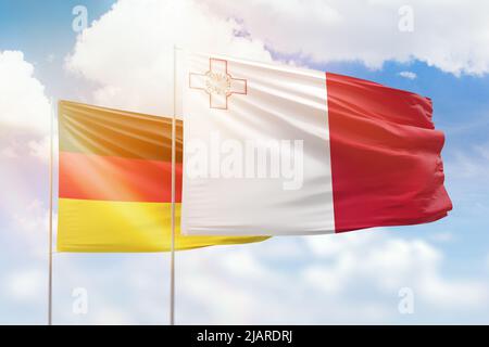 Cielo azzurro soleggiato e bandiere di malta e della germania Foto Stock
