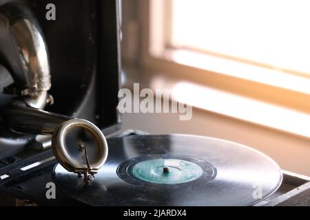 antico grammofono portatile con un disco in vinile ricoperto di polvere Foto Stock