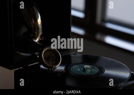 antico grammofono portatile con un disco in vinile ricoperto di polvere Foto Stock