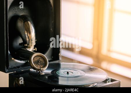 antico grammofono portatile con un disco in vinile ricoperto di polvere Foto Stock