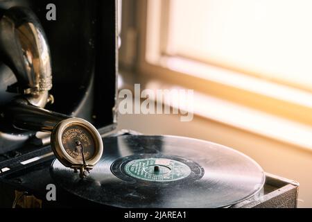 antico grammofono portatile con un disco in vinile ricoperto di polvere Foto Stock